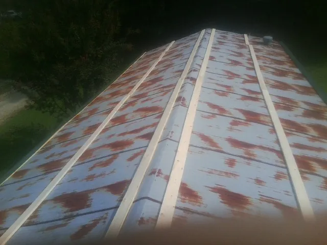Rusted metal roof panels with new wood purlins before replacement — Storm Damage Roof Repair in Anna Maria by Roofing Brothers