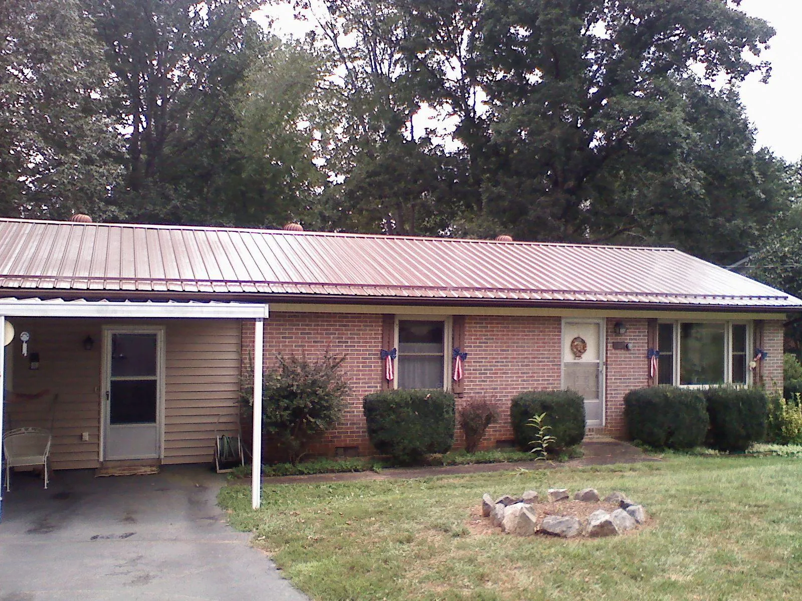 Bronze metal roof and carport on a brick ranch home — Roof Repair work by our crew in Anna Maria